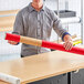 A man holding a red Lavex telescoping mailing tube.