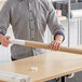 A man holding a Lavex heavy-duty Kraft mailing tube on a table.