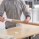 A man holding a Lavex 2 1/2" x 26" kraft mailing tube.