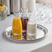 A Thunder Group stainless steel tray with glasses and bottles of juice on it.
