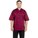 A man wearing a burgundy Uncommon Chef short sleeve chef coat with mesh back.