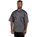 A man wearing a Uncommon Chef slate gray chef coat with a mesh back.