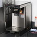 A Bunn airpot coffee brewer on a counter with a tray of condiments.