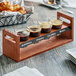 A wooden tray with four Acopa espresso glasses of coffee on it.