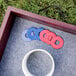 A red and blue circular objects on a grey surface.