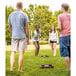 A group of people playing Triumph washer toss in a park.
