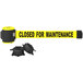 A yellow Banner Stakes magnetic wall mount barrier with black text reading "Closed for Maintenance" hanging on a white wall.