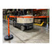 An orange Banner Stakes retractable barrier with "Danger-Forklift Traffic" blocks a forklift in a warehouse.