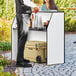 A man standing at a Lancaster Table and Seating foldaway bar with a cooler.