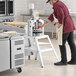 A man using an Estella manual dough divider on a counter in a professional kitchen.