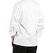 A person wearing a Uncommon Chef white long sleeve chef coat with black stripes on the sleeves.