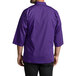 A person wearing a Uncommon Chef grape 3/4 length sleeve chef coat.