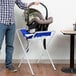 A man holding a Koala Kare white and blue infant seat