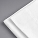 A white Welspun pillow case folded on a gray surface.