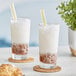 Two glasses of milk with yellow and white straws with Bossen Lychee Powder Mix.