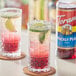 Two glasses of Torani Prickly Pear flavored drinks with lime and a green leaf.