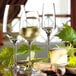 A table with Stolzle Bordeaux wine glasses, cheese, and bread.