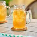 Two Libbey mason jars filled with iced tea on a table.