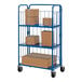 A blue Vestil steel roller container with 3 shelves holding brown boxes with blue trim.