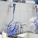 A Waterloo pet grooming faucet with blue hoses and a shower head.