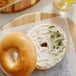 A bagel with Philadelphia Cream Cheese and capers on a plate.