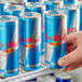 A person holding a Red Bull Sugar Free energy drink can.