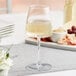An Acopa Piatta white wine glass on a table.