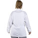 A woman wearing a white Uncommon Chef long sleeve chef coat with a mesh back.