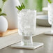 An Acopa Pangea goblet filled with ice water and mint leaves on a table.