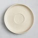 An Acopa Pangea fog white matte porcelain saucer with a circle in the middle.