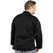 A man wearing a black long sleeve Uncommon Chef Santorini chef coat.