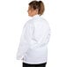 A woman wearing a white Uncommon Chef long sleeve chef coat.