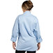 A woman wearing a sky blue long sleeve chef coat.