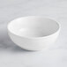 An Acopa Capri coconut white stoneware bistro bowl on a white surface.