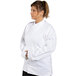 A woman wearing a white Uncommon Chef long sleeve chef coat.