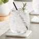 A stemless Acopa Pangea wine glass with ice and a straw in it.