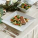 A plate of food with fish and vegetables on it on a table.