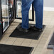 A man standing on a Lavex black anti-fatigue mat.