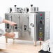 A person pouring coffee into a Cecilware coffee urn.