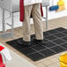 A man standing on a black Choice anti-fatigue floor mat.