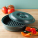 A green HS Inc. polyethylene pot with a lid and tomatoes next to it.