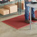 A man standing on a red Lavex anti-fatigue floor mat.