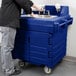 A man using a Cambro navy blue portable self-contained hand sink on a counter.