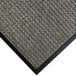 A close up of a grey carpet mat with a black rubber border.