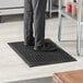 A person standing on a black Choice rubber anti-fatigue floor mat.