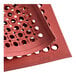 A red rubber Choice anti-fatigue floor mat with beveled edges and holes in it.