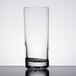 A Libbey tall highball glass filled with a white liquid on a table.