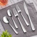 A close-up of a fork and knife on a napkin.