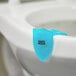 A blue plastic Lavex Ocean Scent gel clip attached to a white toilet.