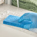 A hand in a blue glove using a Lavex blue cellulose sponge to clean a counter.